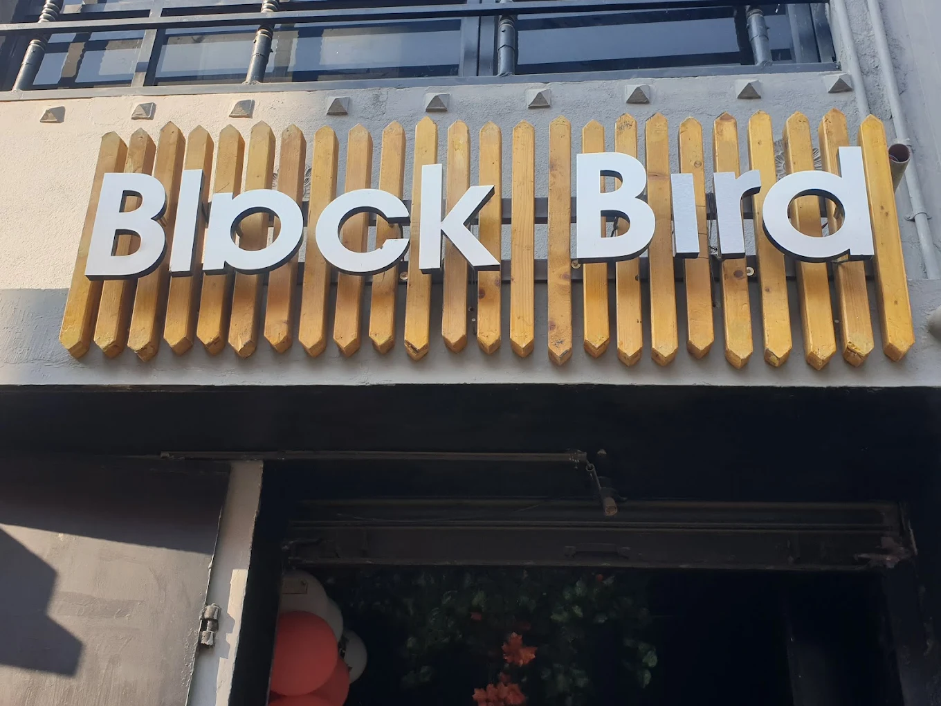 The Black Bird Cafe & Restaurant sign in raised white lettering on wooden slats above the entrance